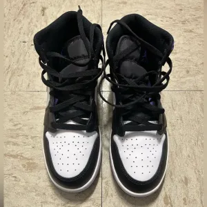 White, black and purple high top shoes